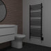 Jeeves Model D Straight Towel Warmer in Matte Black Mounted Beside a Toilet
