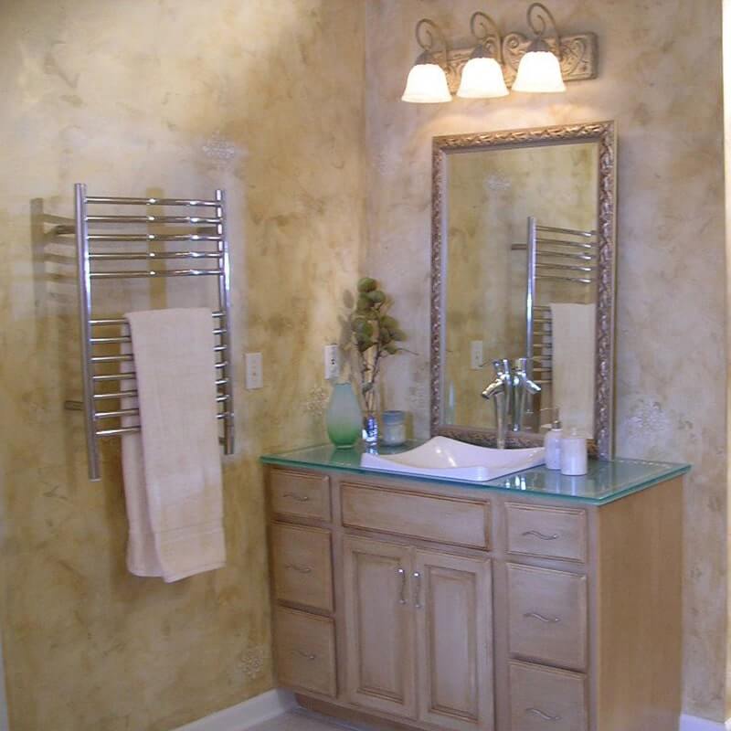 Jeeves Model E Curved Towel Warmer in Polished Stainless Beside Vanity