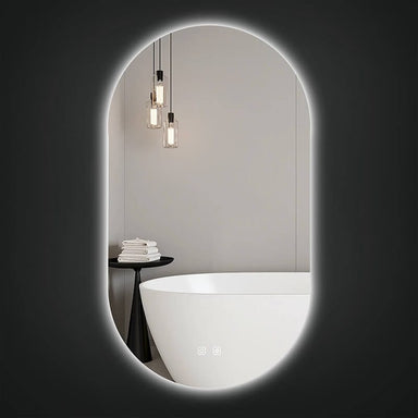 Lexi 20" x 36" oval LED mirror with backlit glow mounted above a freestanding bathtub in a bright bathroom